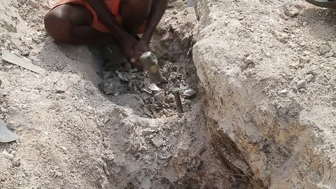 Manual labor in India, poor mine workers breaks chunks of mica. Mining minerals Stockbeeldmateriaal 77631346