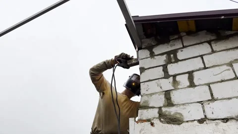 Manual laborer in protective mask welds iron detail at construction Stock Footage 330260312