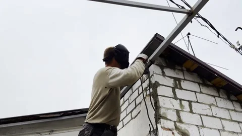 Manual laborer in protective mask welds iron detail at construction. Professiona Stock Footage 340352629