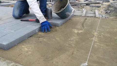 Manual laying process with paving slabs with a rubber mallet - 14s Stock Footage 120023988