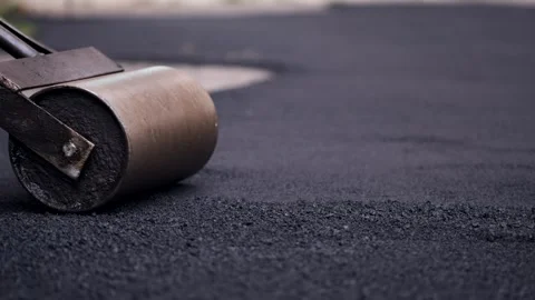 Manual metal roller smoothing fresh hot asphalt on a new sidewalk pavement 動画素材 339801914