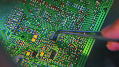 Manual montage of microchips onto the surface of the PCB. Shot via magnifying Stock Footage 221372248
