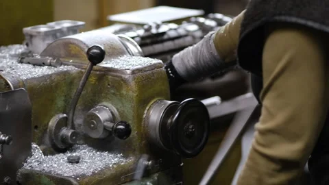 Manual operator using levers to control heavy industrial lathe machine in m.. Stock-Footage 333246387