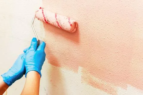Manual painting of a wall using a roller roller, repair concept, Stock Photos