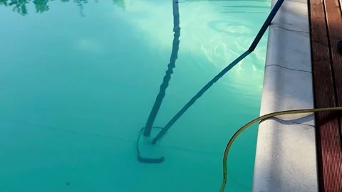 Manual pool cleaner brushing clear blue swimming pool water, static shot. Stock Footage 334318489