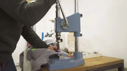 Manual punching press machine. Sewing process. Installing buttons on cloth Stock Footage 164148616