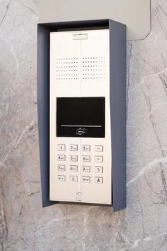 Manual push button, metal keypad of access systems installed on marble wall Stock Photos