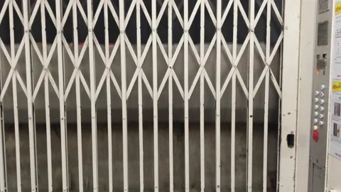 Manual Scissors Gate Of Old Style Elevator Descending In A Building In Video stock 165647956
