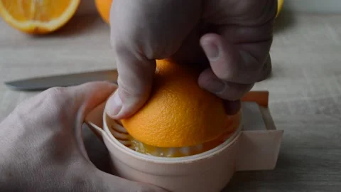 Manual squeezing of oranges and preparation of juice Stock Footage 196994469