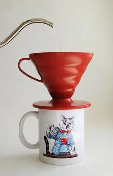 Manual V60 coffee brewing method. Water pours from a gooseneck kettle into red Stock Photos