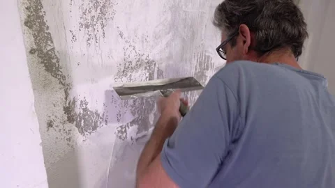 Manual Wall Finishing Technique with Large Metal Taping Knife Stock Footage 323872170