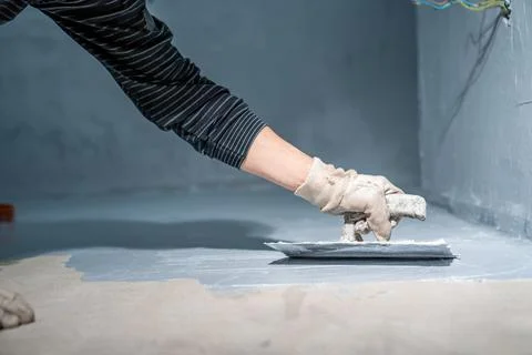 Manual work with bathroom waterproofing using a trowel Stock Photos