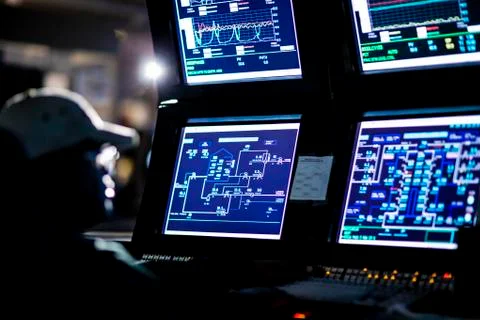 Manual worker with computer monitors in control room at factory 스톡 사진