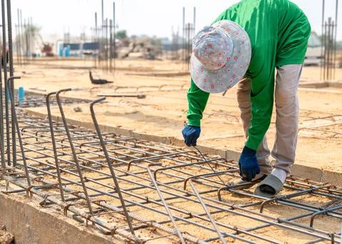 Manual worker at a construction site tying steel rebar grids for a reinforc.. Stock Photos