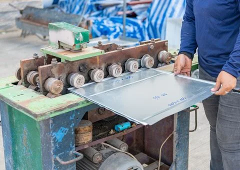 Manual worker loading metal sheet in folding machine. Stock-Fotos
