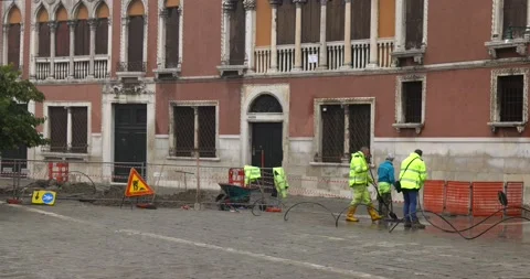 Manual workers with masks doing sidewalks maintenance and work in a square Stock Footage 150197859