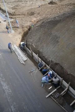 Manual workers mount span of bridge on the roadway Photos