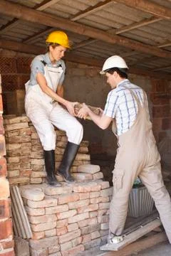 Manual workers moving bricks at a building site Foto stock