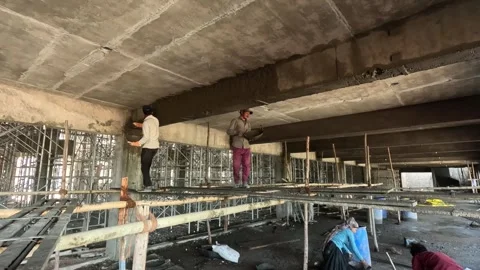 Manual Workers Plastering Ceiling Surface on Scaffolding at Building 動画素材 340564314
