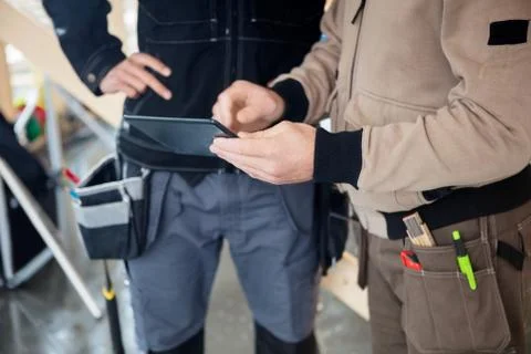 Manual Workers Using Digital Tablet At Site Foto stock