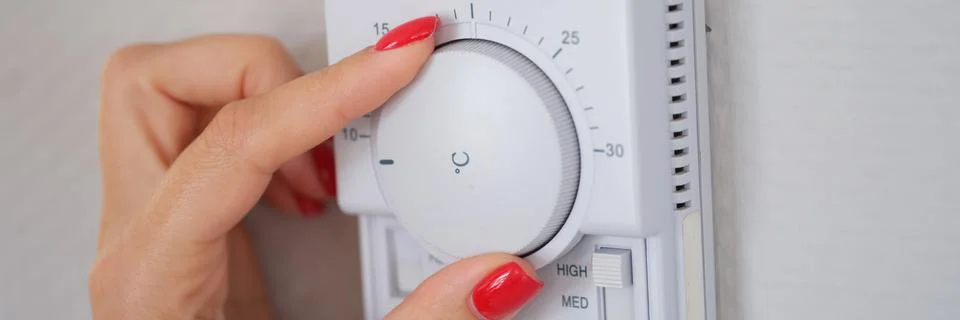 Manually adjust temperature in central heating control panel Stock-Fotos