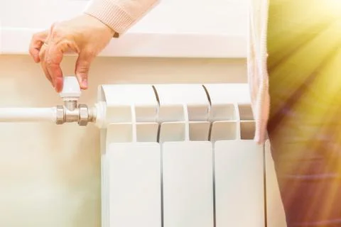 Manually adjust the volume of heating valve on the radiator Stock Photos