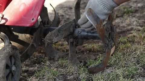 Manually repair a walk-behind tractor in a field Stock Footage 130621341