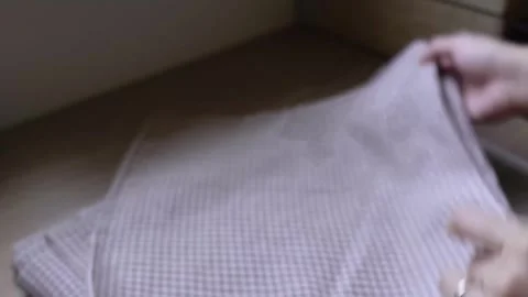 Manually sorting through and folding a checkered cloth Stock Footage 315084810