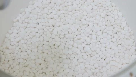 Manufactured white pills are being dropped into container. close-up of white Stock Footage 200856465