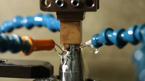 Manufacturing process shapes metal by creating sparks from EDM machine Stock Footage 108425912