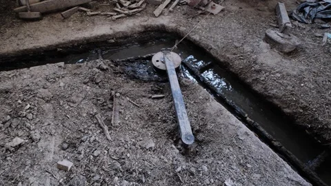 Manure scraper system inside a dirty cattle barn with drainage gutter Stock Footage 346310652