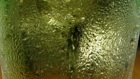 Many air bubbles and foam moving slowly from cold yellow beer on a clear glass, 스톡 동영상 83109512