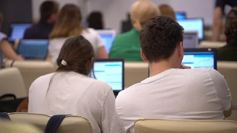 Many attentive students watching a presentation in a lecture theatre. College Stock Footage 89772574