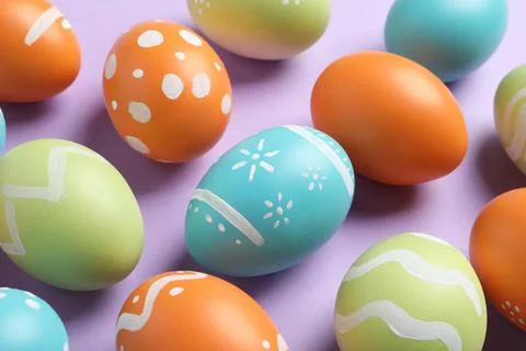 Many beautiful painted Easter eggs on color background, closeup Foto stock
