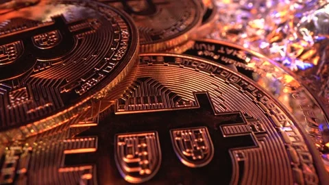 Many Bitcoin BTC rotate on the table, Super Macro shot. Golden coin. Rich shot Stock Footage 129616719