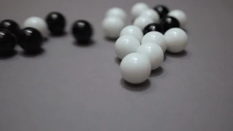 Many black and white balls colliding and rolling across gray surface Stock Footage 147458558