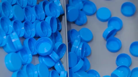 Many blue plastic bottle caps moving on conveyor belt - production line Vidéo 153796623