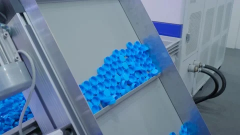Many blue plastic bottle caps moving on conveyor belt - production line Vidéo 154867122