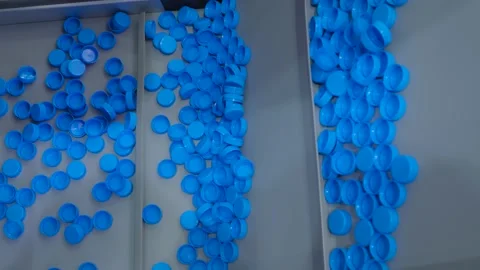 Many blue plastic bottle caps moving on conveyor belt - production line Vidéo 156056328