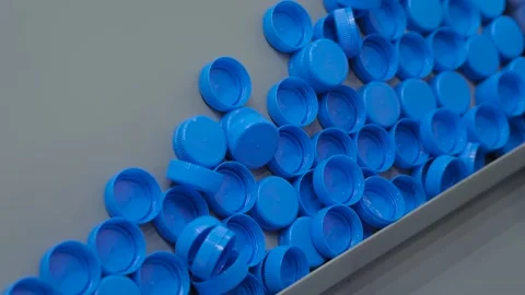 Many blue plastic bottle caps moving on conveyor belt - production line Vidéo 156056782