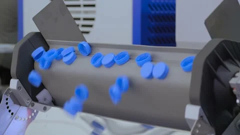 Many blue plastic bottle caps falling from conveyor belt - production line Vidéo 158645665