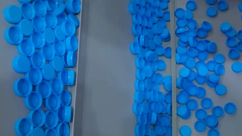 Many blue plastic bottle caps moving on conveyor belt - production line Vidéo 161156744