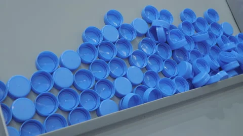Many blue plastic bottle caps moving on conveyor belt - production line Vidéo 164071107