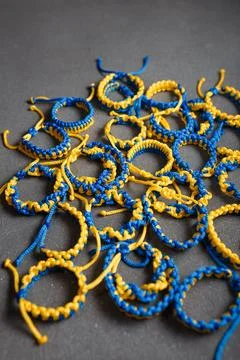 Many blue yellow macrame bracelets. Wristbands in national Ukrainian flag colors 库存照片