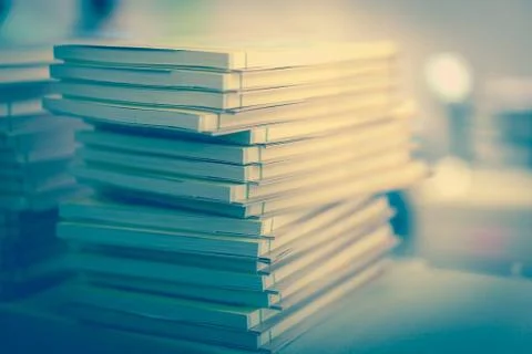 Many books stacked on a table in a library. Stock Photos