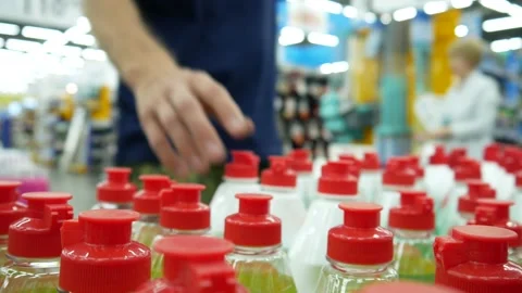 Many bottles of dishwashing liquid in a hardware store and a buyer takes one Stock Footage 195975166