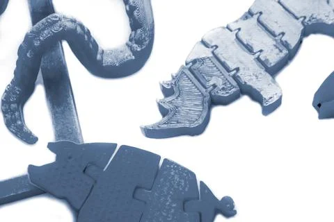 Many bright multi-colored objects printed on 3d printer lie on flat surface Stock Photos