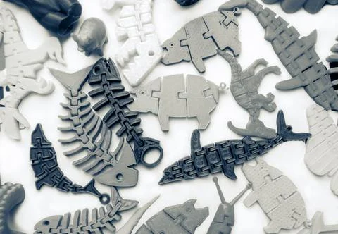 Many bright multi-colored objects printed on 3d printer lie on flat surface Stock Photos