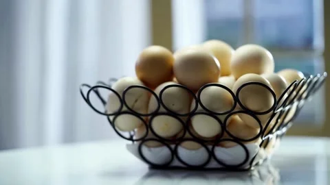 Many brown chicken eggs in a black wire basket Stock Footage 333809142
