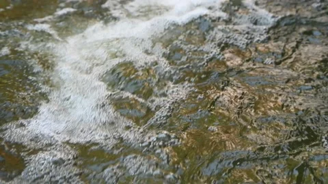 Many bubbles are created from a waterfall on a mountain stream (slow motion) Stock-Footage 219394106